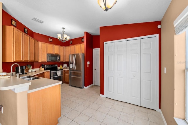 kitchen featuring kitchen peninsula, stainless steel appliances, sink, an inviting chandelier, and lofted ceiling