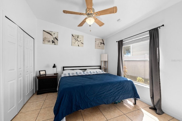 bedroom featuring light tile patterned floors, a closet, and ceiling fan