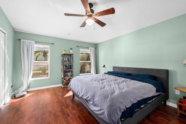 bedroom featuring ceiling fan, dark hardwood / wood-style flooring, and a textured ceiling