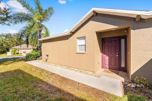 doorway to property featuring a yard