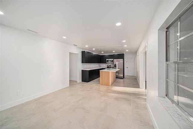 kitchen featuring appliances with stainless steel finishes and a center island with sink