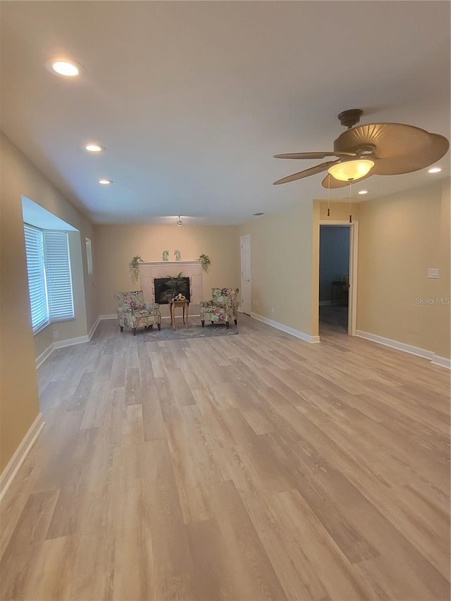 unfurnished living room featuring ceiling fan and light hardwood / wood-style flooring