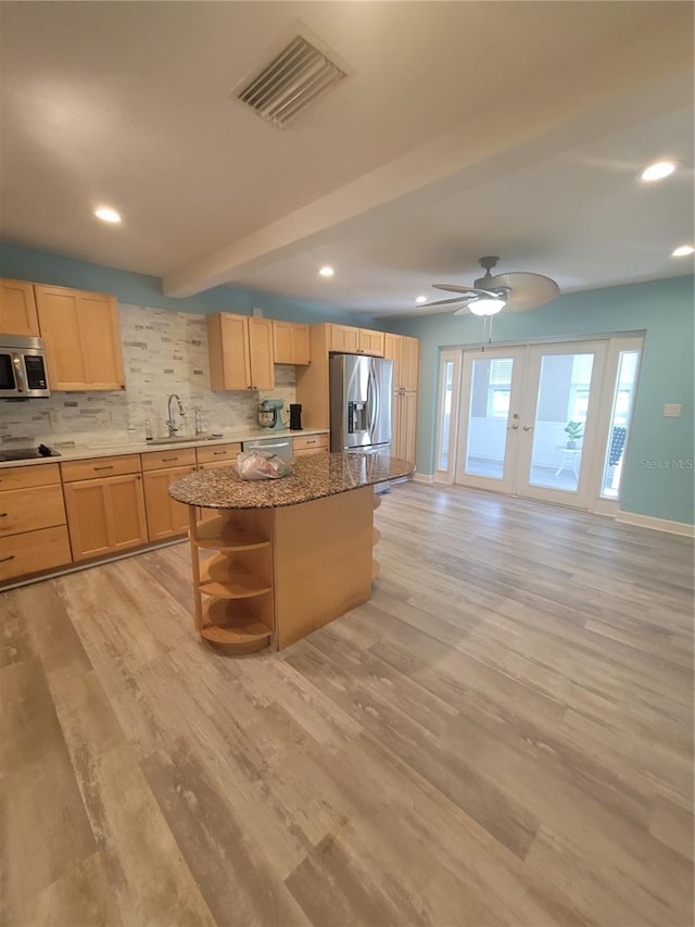 kitchen featuring light wood-type flooring, french doors, a center island, and stainless steel appliances