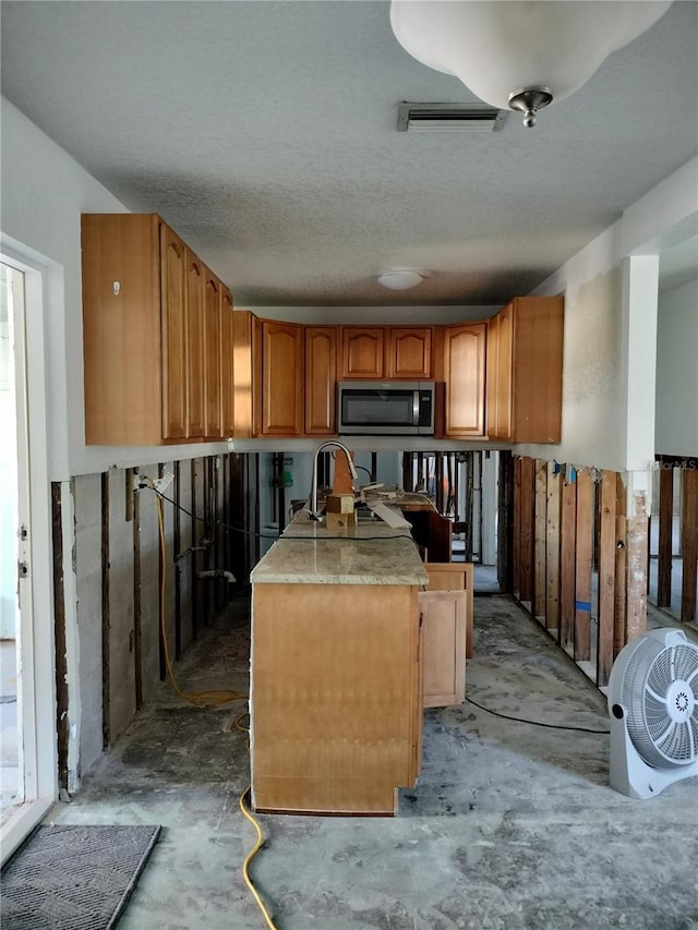 kitchen with sink, concrete floors, and a textured ceiling