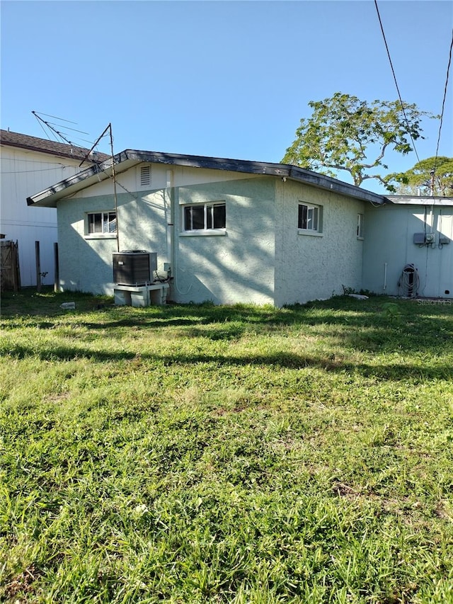 back of house with a yard and central air condition unit