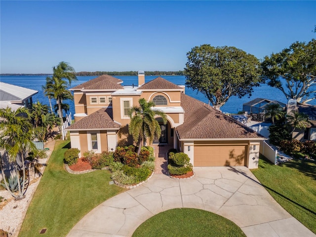 mediterranean / spanish house featuring a garage, a water view, and a front yard