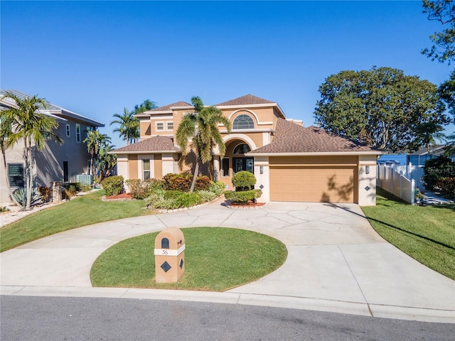 mediterranean / spanish home featuring a front yard and a garage