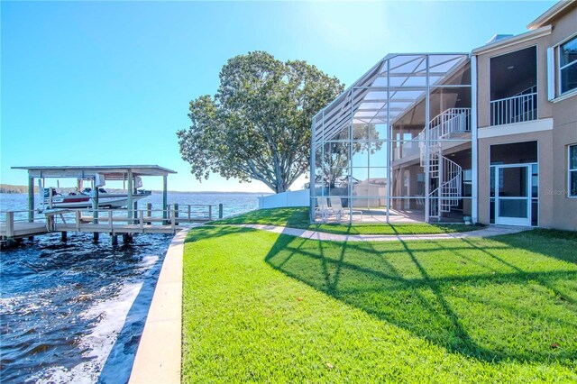 view of yard featuring a lanai, a dock, and a water view