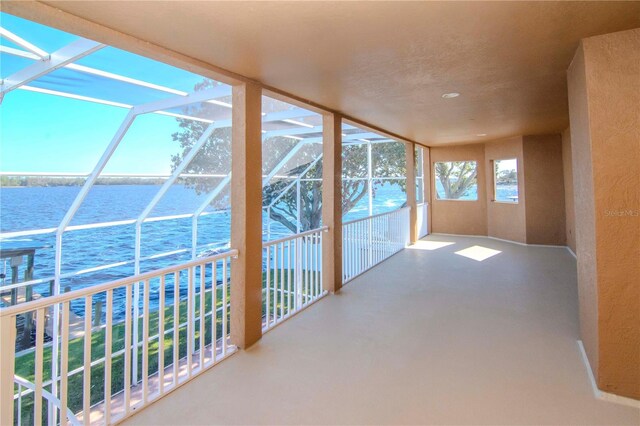 unfurnished sunroom featuring a water view