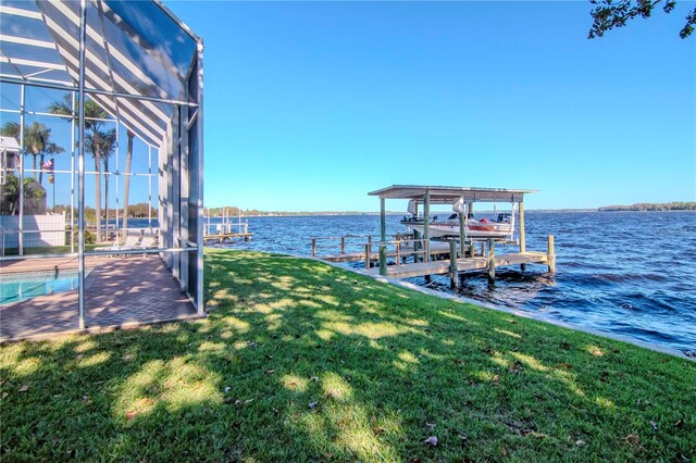 dock area featuring a lanai, a water view, and a lawn