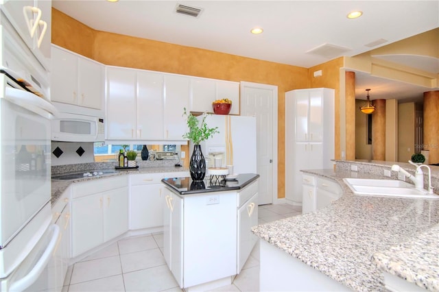 kitchen with white cabinetry, sink, a kitchen island, and white appliances