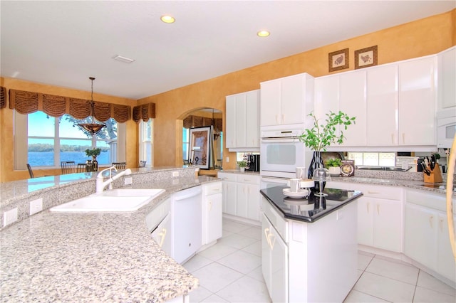 kitchen featuring a center island, a water view, and white cabinetry