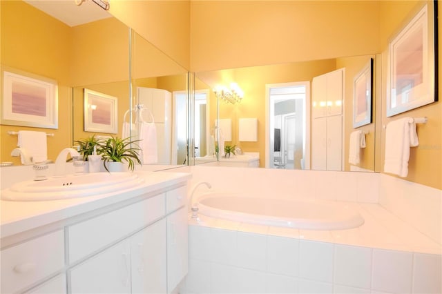 bathroom featuring tiled tub and vanity