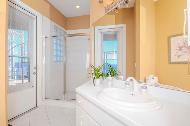 bathroom featuring tile patterned flooring, vanity, a healthy amount of sunlight, and a shower with door