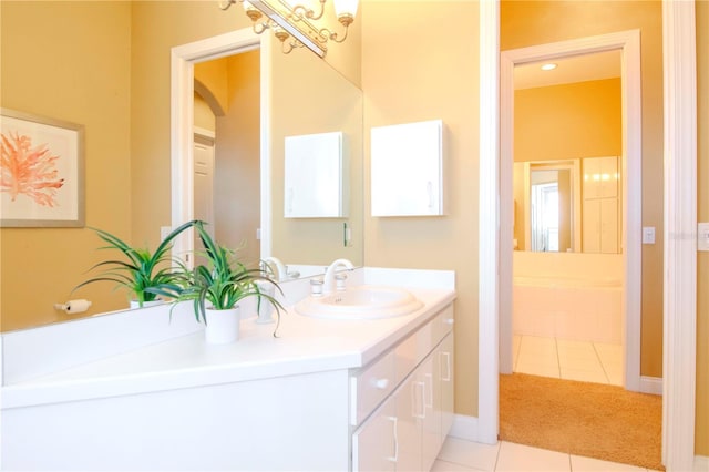 bathroom featuring tile patterned flooring, vanity, and tiled bath