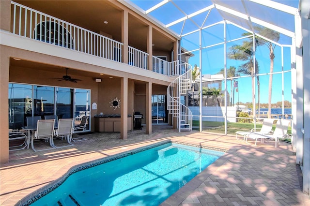 view of swimming pool featuring a lanai, ceiling fan, and a patio area