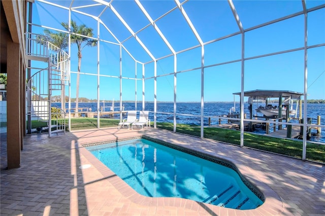 view of pool featuring glass enclosure, a water view, a patio, and a boat dock