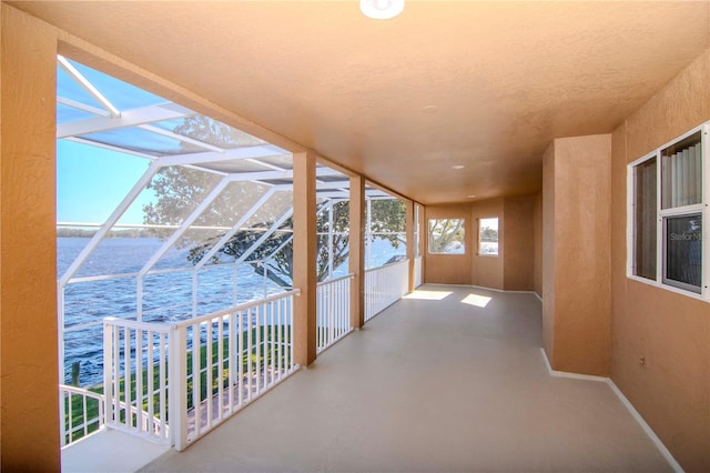 interior space with glass enclosure and a water view