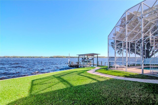 dock area with a water view, glass enclosure, and a lawn