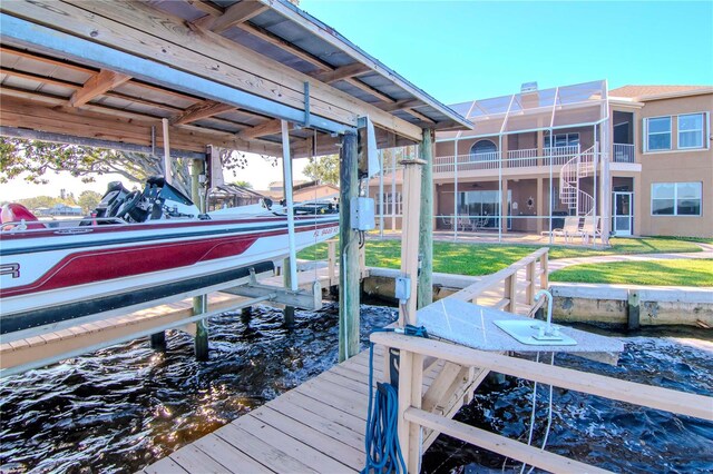 view of dock with a yard and a water view