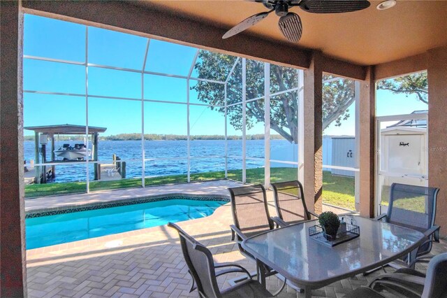 view of pool featuring a water view, ceiling fan, a lanai, a storage unit, and a patio