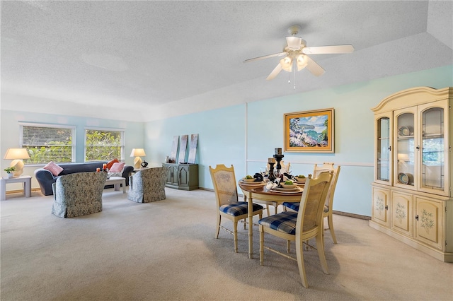 dining room featuring light carpet, a textured ceiling, and ceiling fan