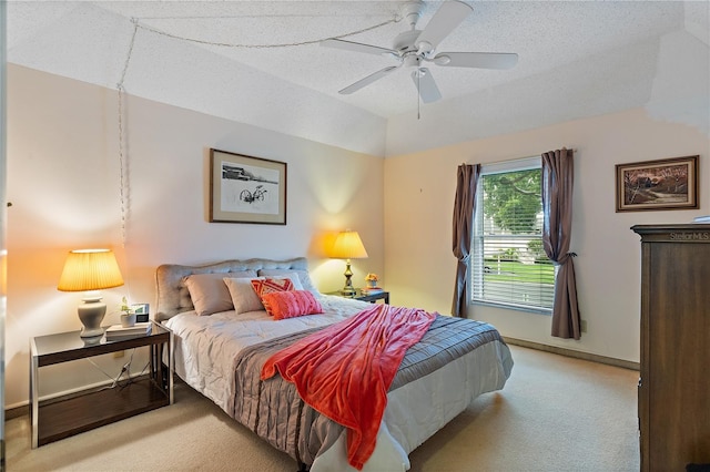 bedroom featuring vaulted ceiling, ceiling fan, light carpet, and a textured ceiling