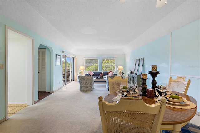 carpeted dining room featuring a textured ceiling