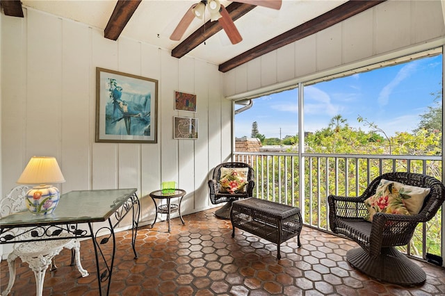 sunroom with ceiling fan and beamed ceiling