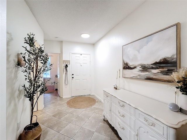 entryway featuring a textured ceiling and light tile patterned flooring