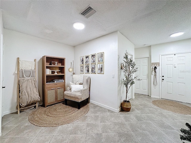 living area featuring light tile patterned floors and a textured ceiling