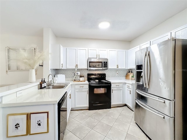 kitchen featuring sink, kitchen peninsula, decorative backsplash, white cabinets, and black appliances