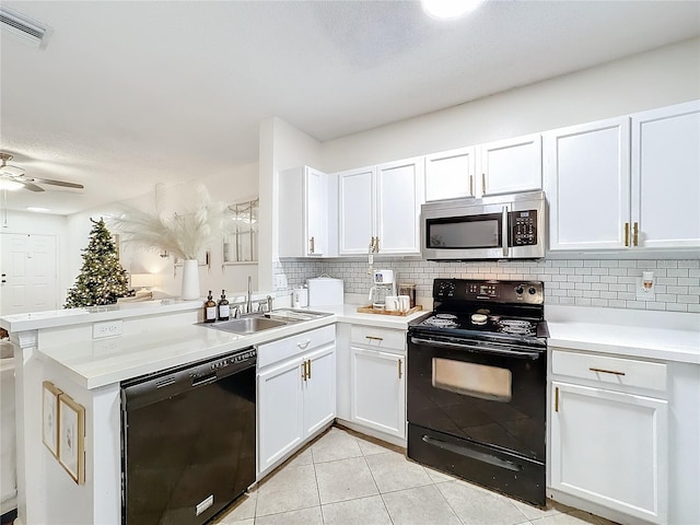 kitchen with white cabinetry, sink, kitchen peninsula, light tile patterned floors, and black appliances