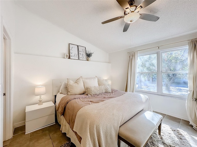 bedroom with tile patterned flooring, a textured ceiling, vaulted ceiling, and ceiling fan