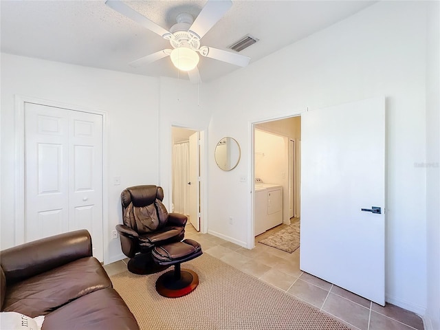 interior space featuring light tile patterned floors, washing machine and dryer, and ceiling fan