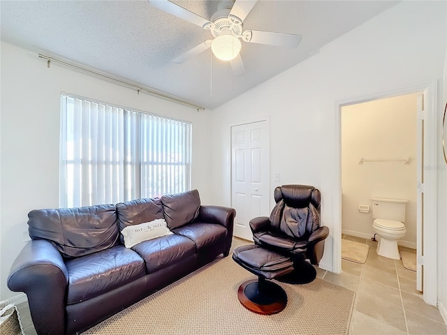 tiled living room with ceiling fan, a textured ceiling, and vaulted ceiling