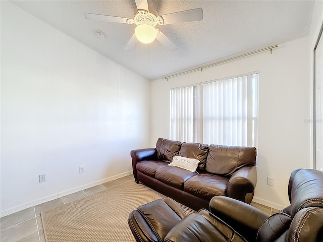 tiled living room with ceiling fan and a textured ceiling