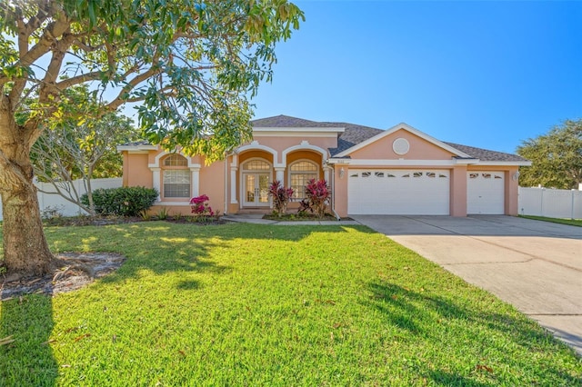 view of front of property with a front yard, french doors, and a garage