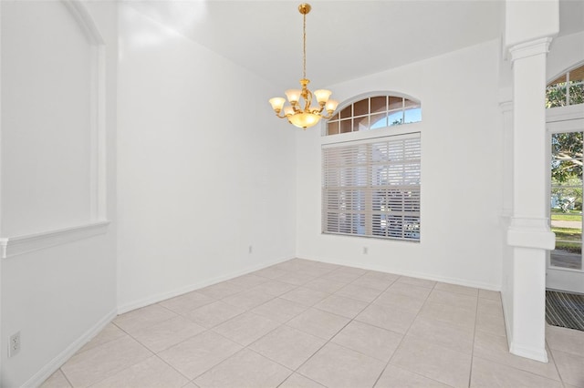 empty room with a chandelier and light tile patterned floors