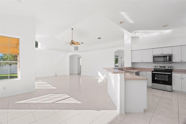 kitchen featuring kitchen peninsula, appliances with stainless steel finishes, ceiling fan, light tile patterned floors, and white cabinets