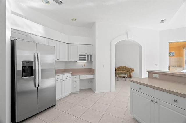 kitchen with white cabinets, stainless steel fridge with ice dispenser, and light tile patterned floors