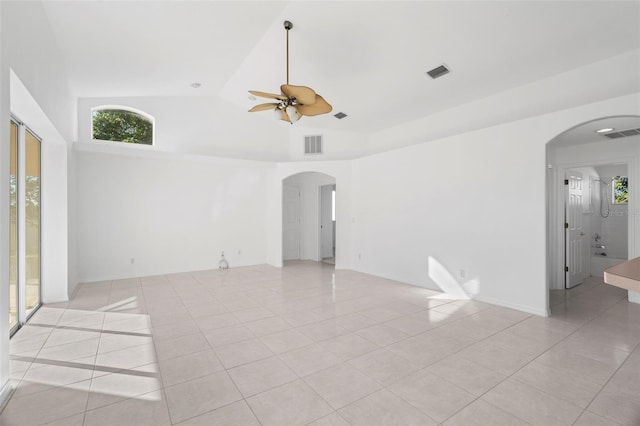 empty room with light tile patterned floors, high vaulted ceiling, and ceiling fan