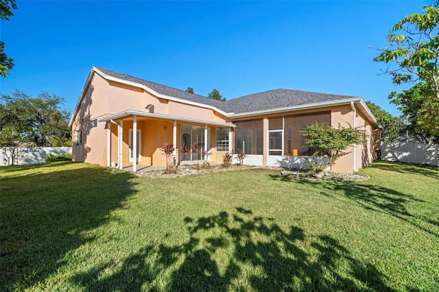 back of house with a sunroom and a yard