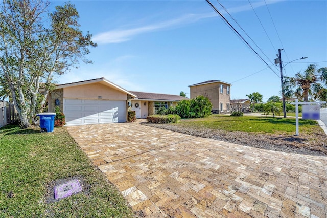 single story home featuring a front lawn and a garage