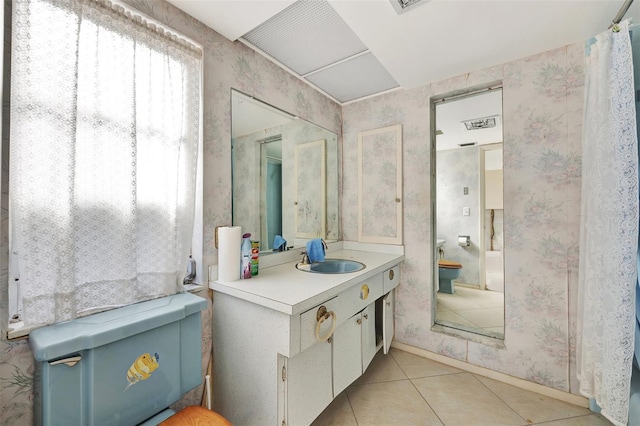 bathroom with tile patterned flooring, vanity, and toilet