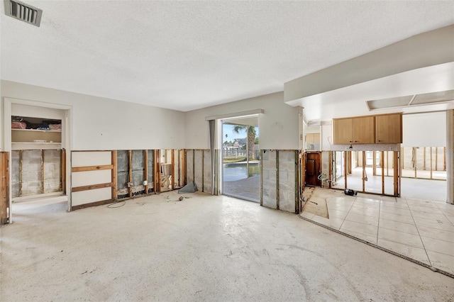 tiled empty room with a textured ceiling