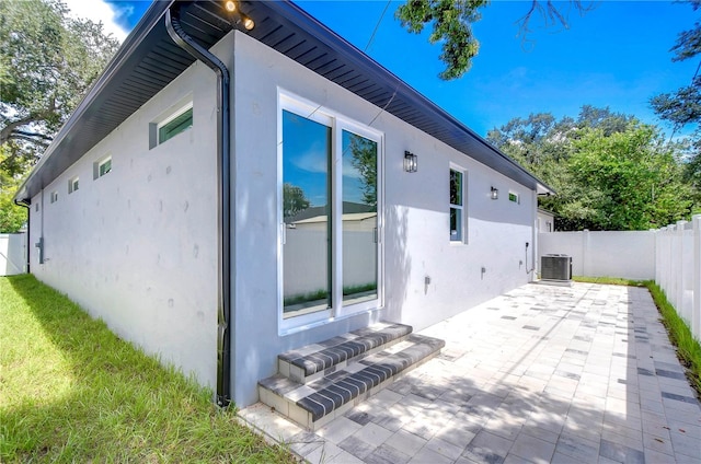 view of side of home featuring cooling unit and a patio area