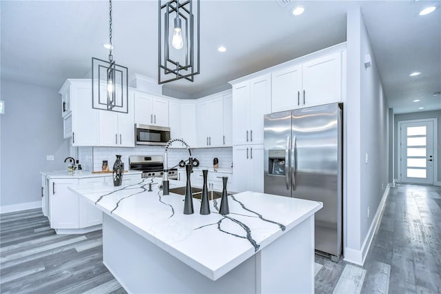 kitchen with white cabinetry, an island with sink, pendant lighting, and appliances with stainless steel finishes