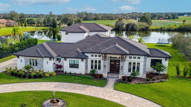 view of front of house featuring french doors, a water view, and a front yard