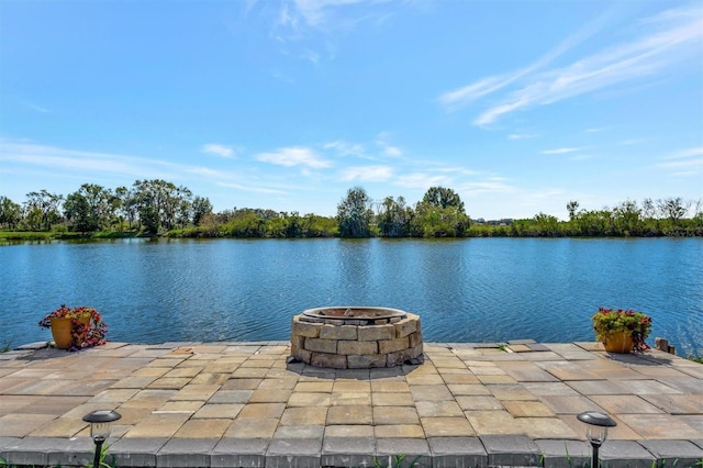 view of patio with a water view and a fire pit